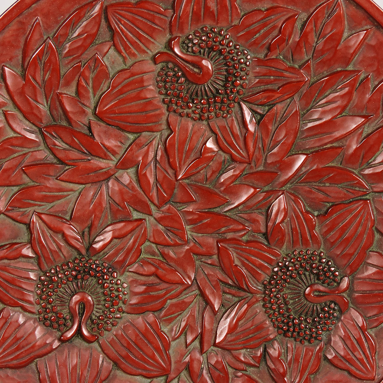 This lovely Japanese round red lacquer plate with hand-carved blossoms and leaves was crafted in a technique known as Kamakura-bori and dates to the early 20th century. Measures: Diameter 9 1/2 inches.