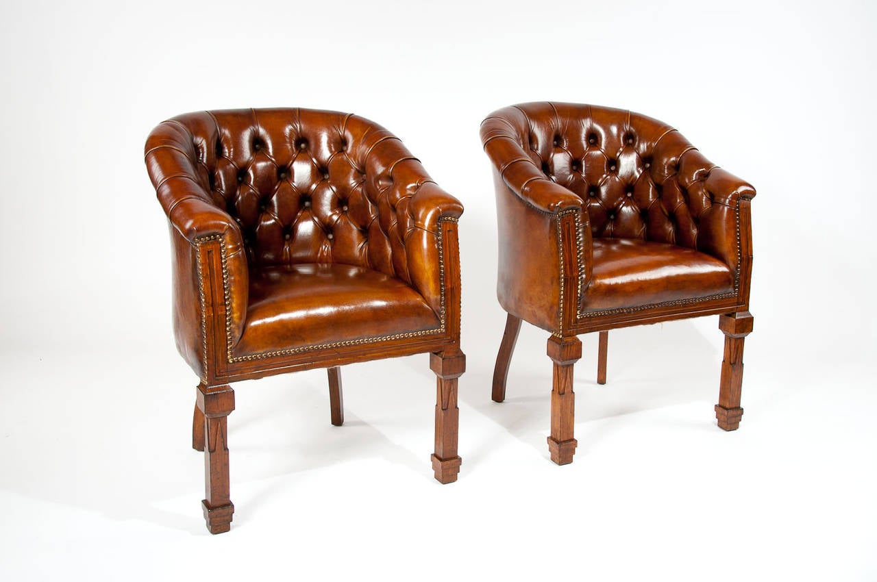 A very good quality pair of leather upholstered tub chairs on shaped and moulded front legs. This rare pair of tub armchairs dating to the Victorian era having a beautifully shaped and deep buttoned back of generous proportions with a fully