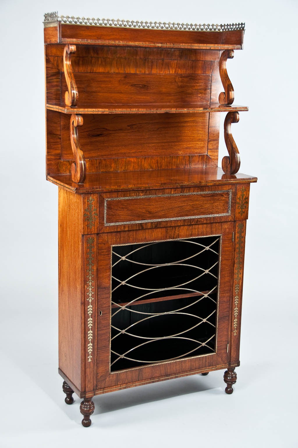 A stunning quality Regency antique rosewood and brass inlaid chiffonier with two-tier upstand. This fine quality Regency chiffonier decorated with brass inlay has a two-tier upstand supported by brass strung 's' shaped scrolls having a brass fretted