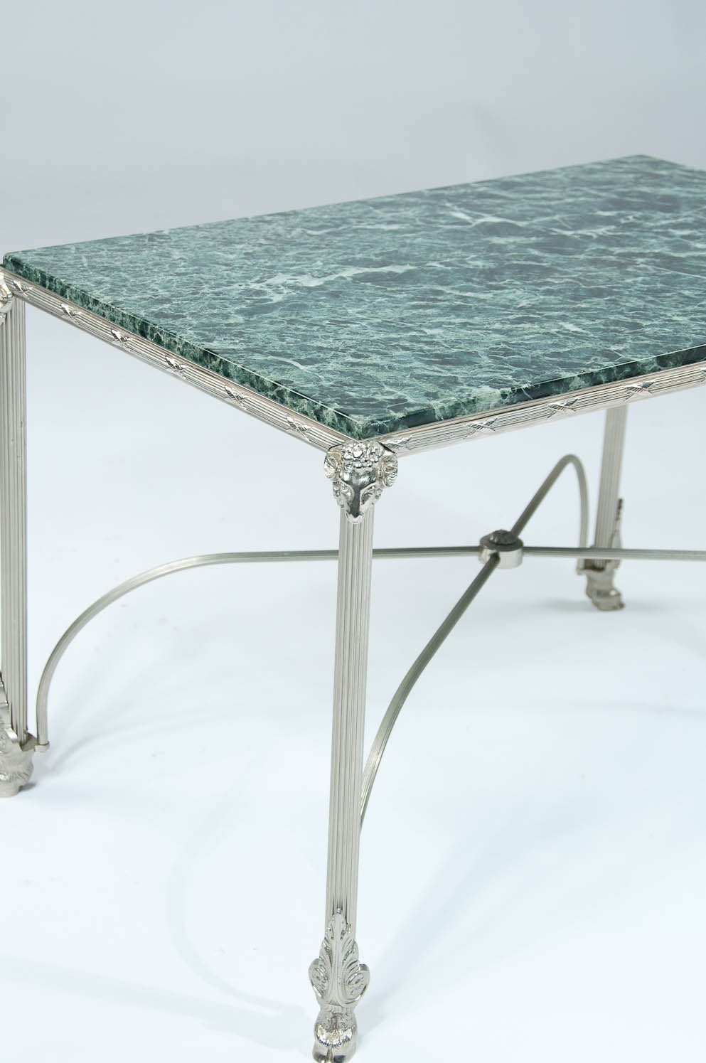 A very fine quality 1920s nickel-plated marble-topped occasional table. Having a very good quality veined marble top supported by four reeded legs with rams head capitals united by a shaped X-frame stretcher raised on hoof feet. In superb condition