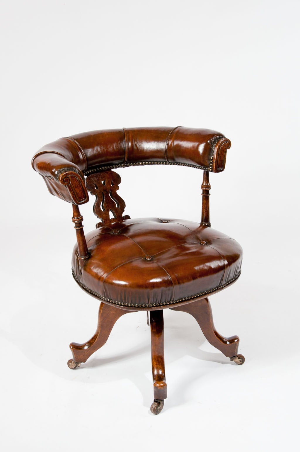 A good quality Victorian oak leather upholstered and buttoned swivel desk chair. Dating to circa 1880 this quality swivel desk chair has a leather upholstered shaped back for comfort supported by a shaped oak splat and finely turned columns to the
