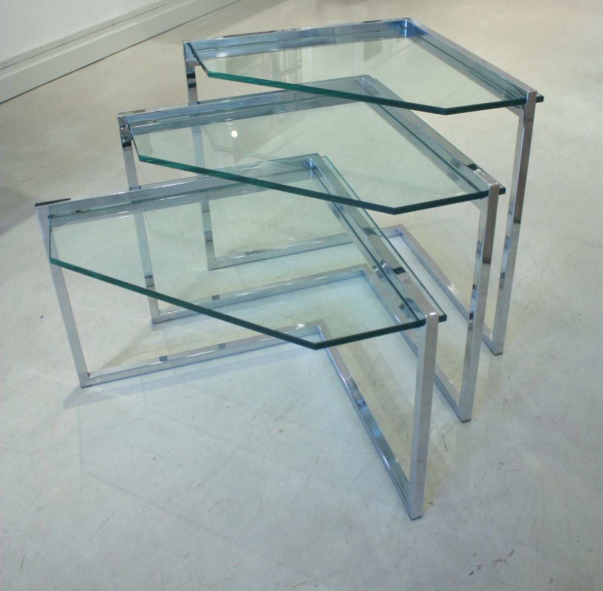 Set of three vintage chrome and glass nesting tables.