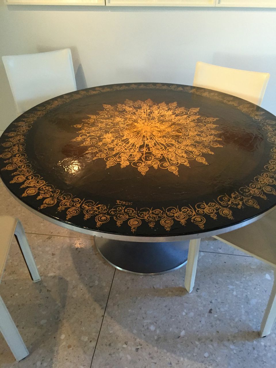 This unusual pedestal dining table has a gilt decorated leather top on a brushed aluminum base. Manufactured by France & Son (label underneath) and designed by Danish designer, Mygge (signature on top).