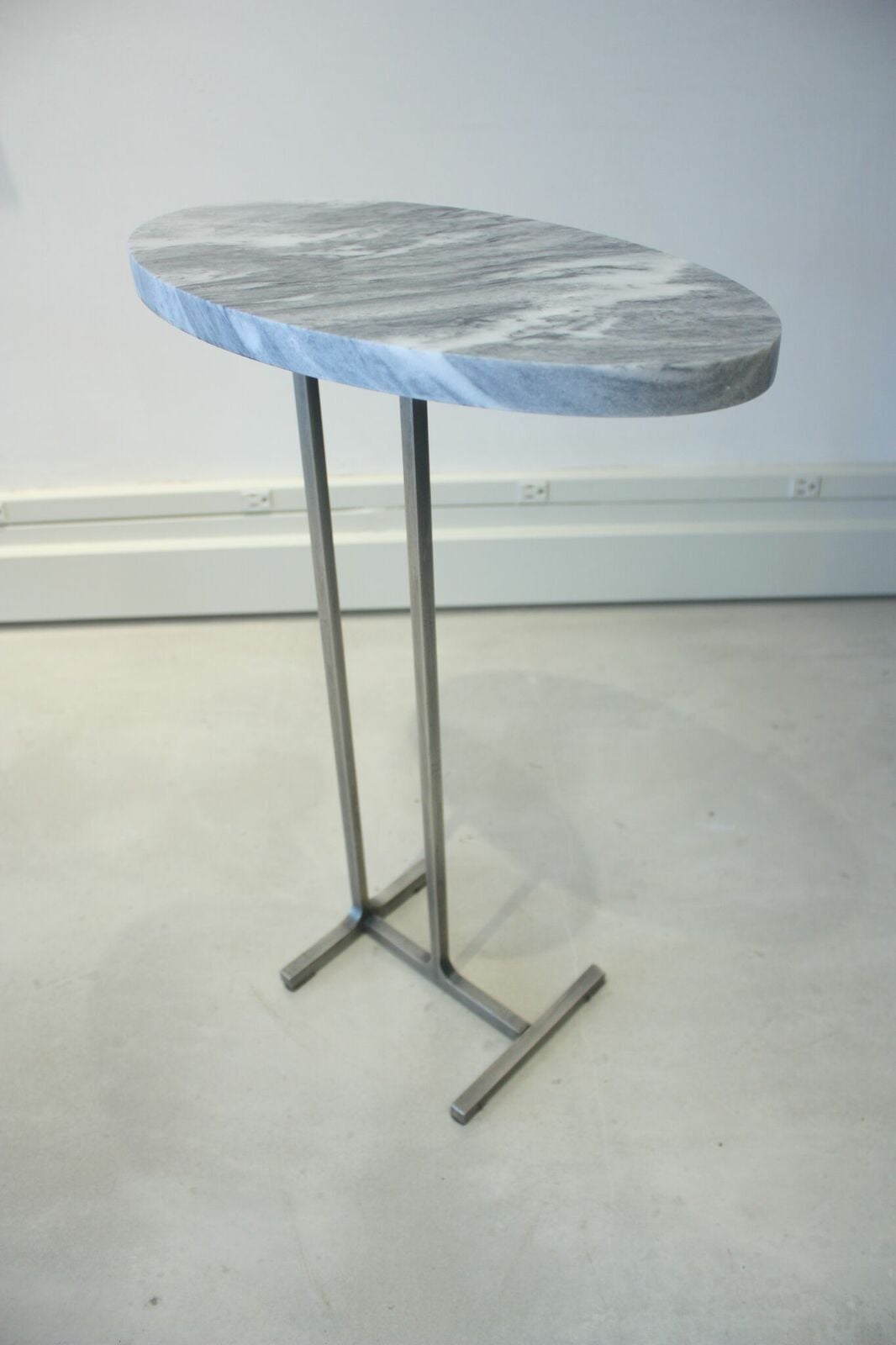 Emily Summers Studio Line - Ozzie Drink Table.  Manchester Grey Marble with a Blackened Steel base.