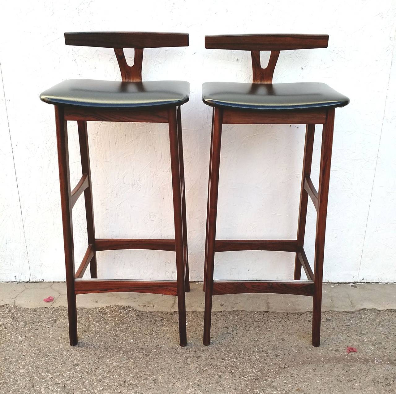 Incredible pair of 1960's bar stools sculpted of gorgeous rosewood. Labeled 