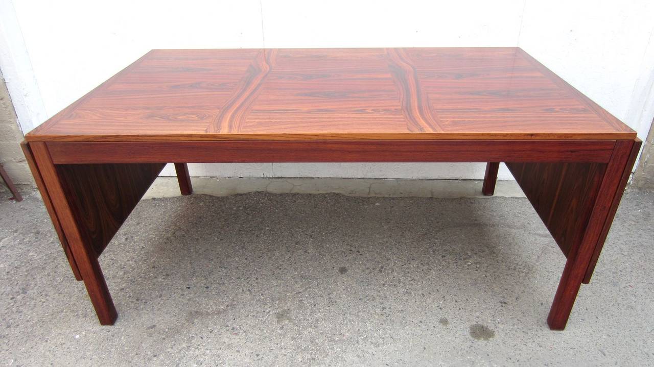 A gorgeous Danish Modern rosewood drop leaf dining table designed by Kai Winding.
8 feet 9