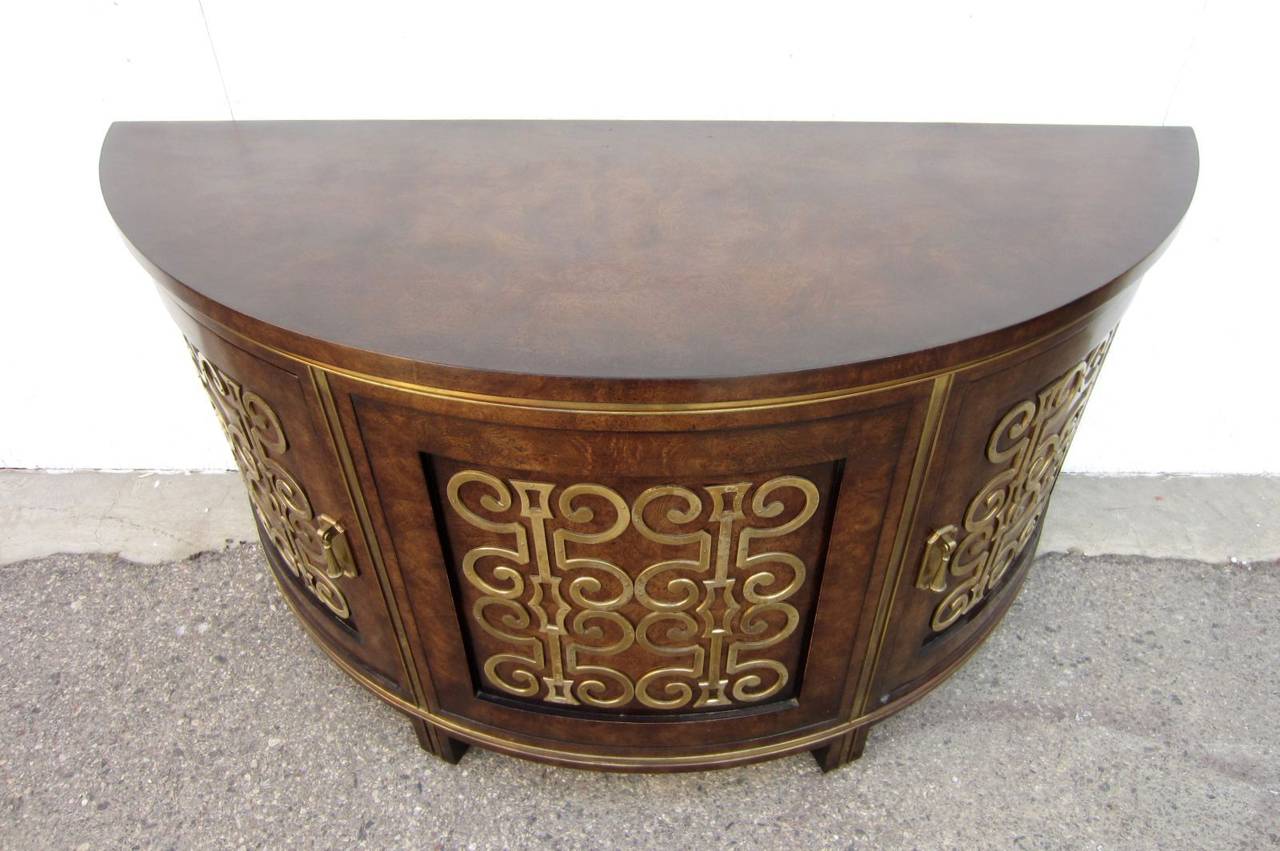 Very rare piece designed by William Doezema for Mastercraft furniture.
Demilune two-door burl wood cabinet with applied swirl brass design.
Single center shelf runs straight through from both sides.
 