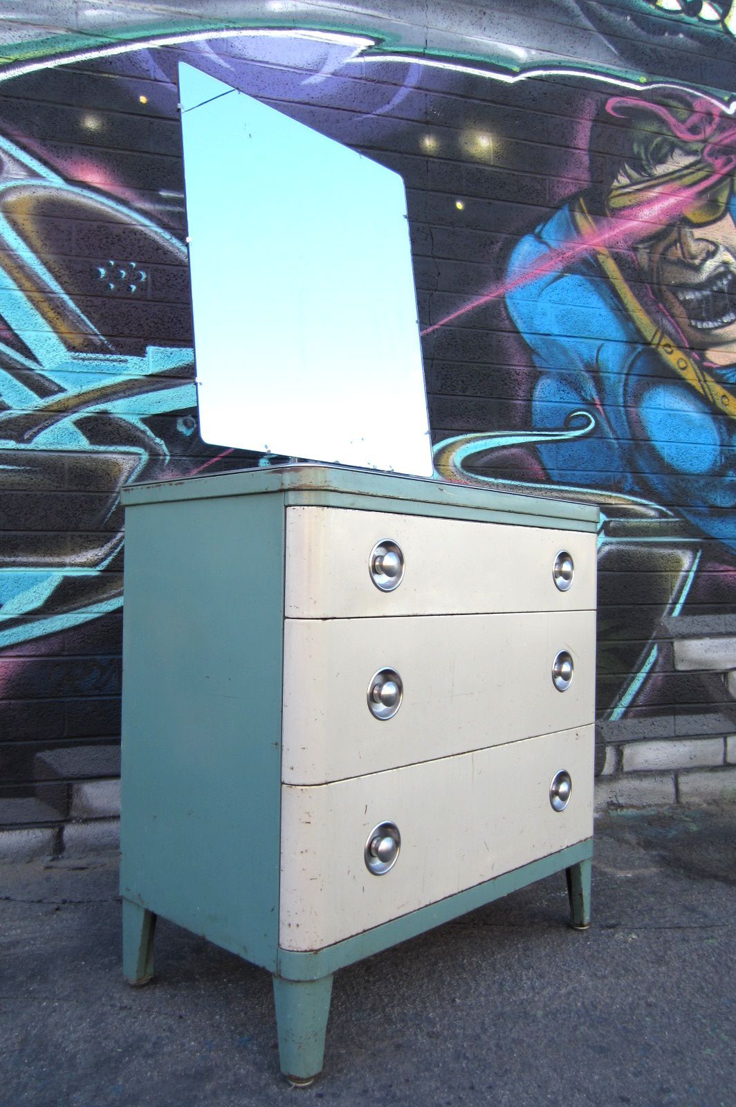 Circa 1930's completely original un-restored Norman Bel Geddes design for Simmons furniture steel 3 drawer dresser with floating mirror.
Light blue and white enamel with brushed stainless steel pulls.
Mirror pivots front to back.  A Killer