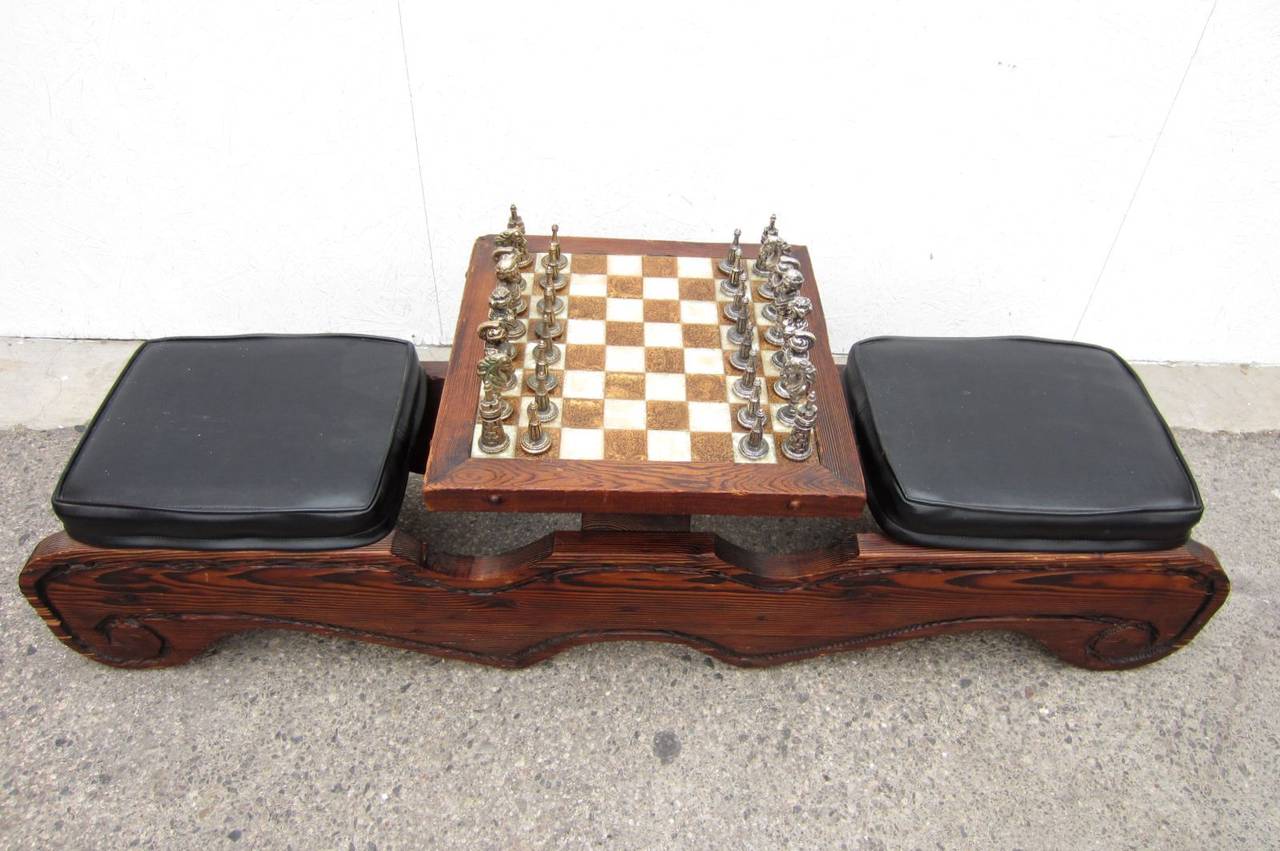 Very rare 1960s Witco chess table/bench with original metal game pieces.
Made of thick sculpted swamp cedar with black vinyl seating.
Low face to face game board table made of checkered cream/brown composite plastic.
Game pieces are made of solid
