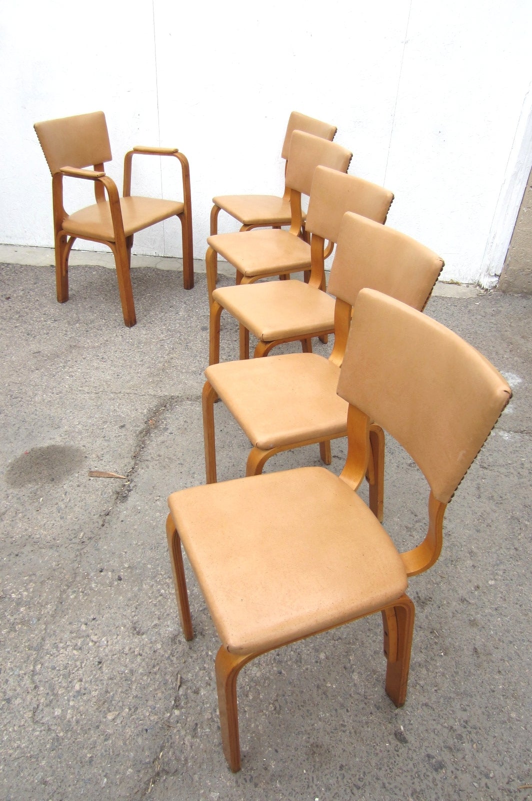 Thonet, Austria circa 1940s dining chairs of golden birch bentwood.
Bauhaus design with a touch of industrial that never goes out of style. 
They are all original, unrestored.
Five side chairs and one large 