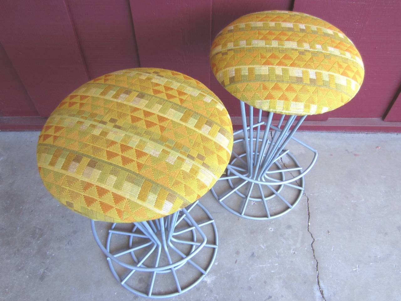 Pair of mid-century modern steel wire stools attributed to Frederick Weinberg with Alexander Girard fabric upholstered cushions.
These stools are sculpted of 3/8