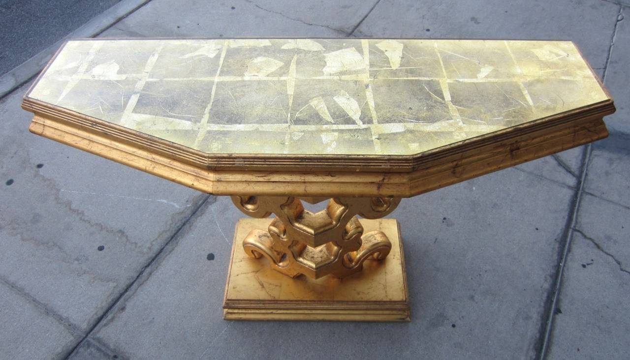 Sculptural gleaming gold console table with gold gilded glass top in the manner of James Mont
Beautiful piece of accent furniture.