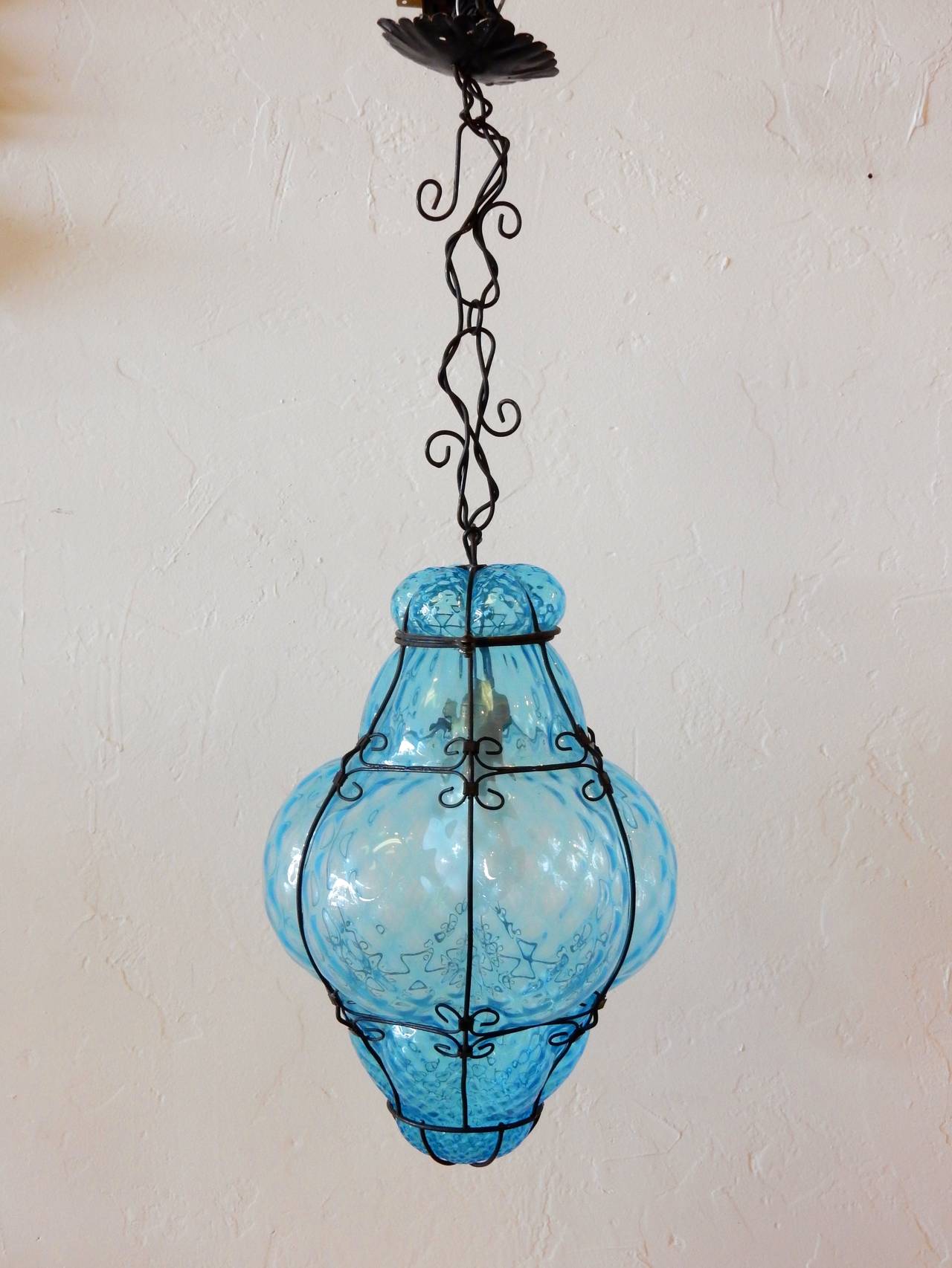 1960's Italian Murano hand blown aqua blue cage lantern pendant lamp with sculpted black iron chain and hardware.
Fabulous piece!