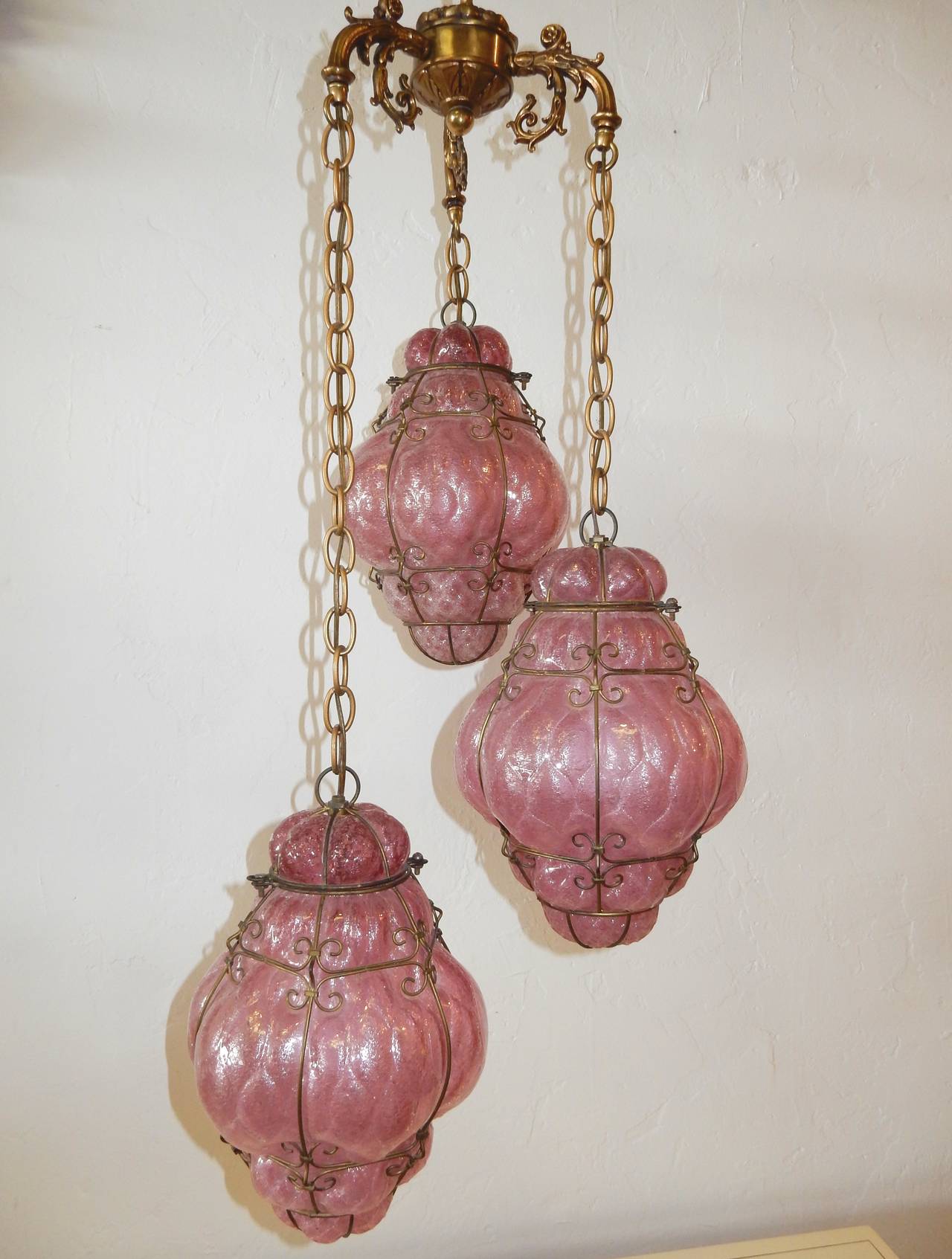 Fabulous triple pendant cage art glass chandelier from Murano Italy circa 1950's
Hand blown translucent PINK glass with brass cage, chain and hardware.