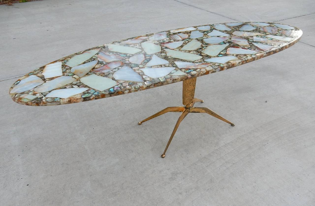 Gorgeous coffee table table attributed to Arturo Pani, Mexico 1950's
Onyx and abalone surfboard top sets on a solid brass spider leg base.