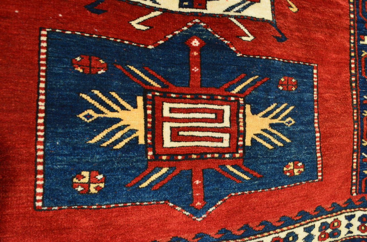This powerful early 19th century Bordjalu Kazak in perfect condition comes from the Southeastern part of Georgia. Its shamanist sprit gives birth to a TOTEM in radiant strength with an aura of fire, encircled by a garland of waves and