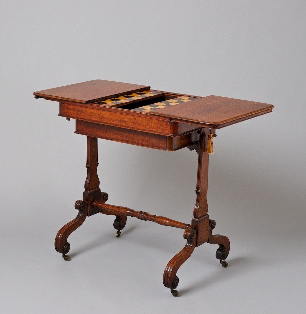 A small elegant Regency mahogany games table, the interior with chess and backgammon boards.