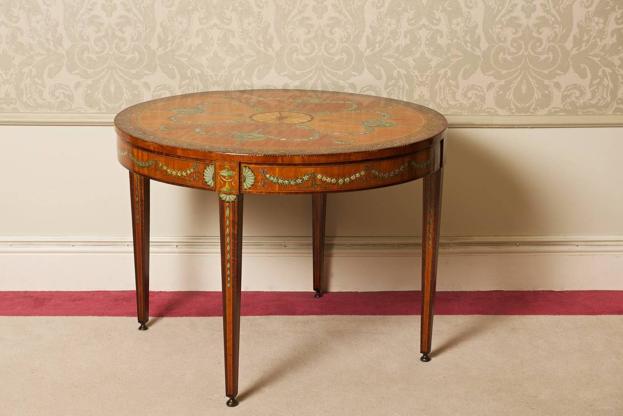 An Edwardian satinwood table with inlays and painted decoration (the four seasons)