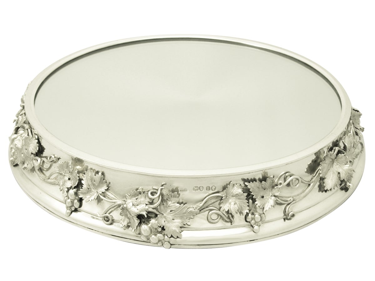 An exceptional, fine and impressive antique Victorian English sterling silver mirrored plateau; an addition to our presentation silverware collection.

This exceptional Victorian sterling silver mirrored plateau has a circular flared form with a
