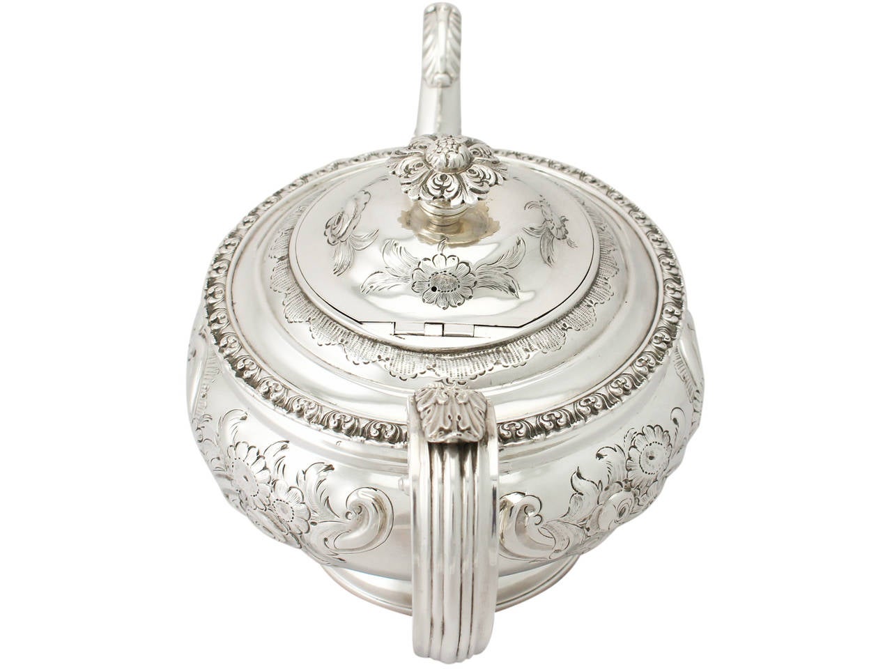 A fine antique George IV Scottish sterling silver teapot; part of our silver teaware collection.

This fine antique George IV Scottish sterling silver teapot has a circular compressed form onto a circular spreading foot.

The body of the teapot