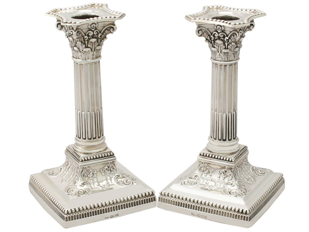 A fine and impressive pair of antique George V English sterling silver Corinthian column candlesticks; part of our ornamental silverware collection.

These fine antique George V sterling silver candlesticks have Corinthian columns to a square