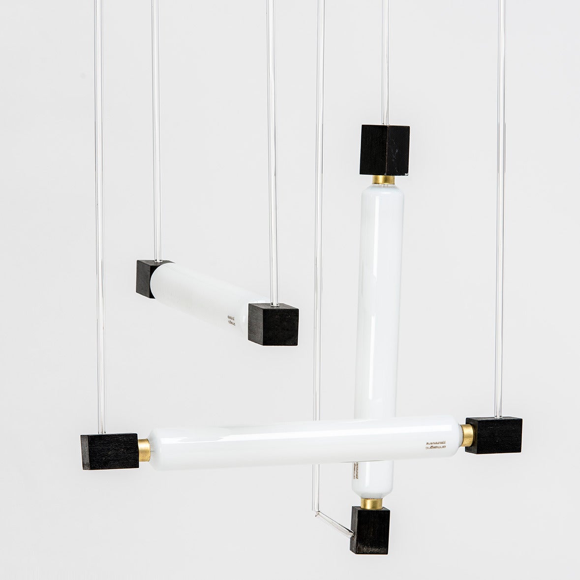 Hanging lamp, designed by Rietveld in 1922, executed in 1969 by Gerard van
de Groenekan, the cabinetmaker of Rietveld. Commissioned by Paul F. Rickmans.
Two horizontal tubes and one vertical, locked at both sides by ebonized wooden square blocks.