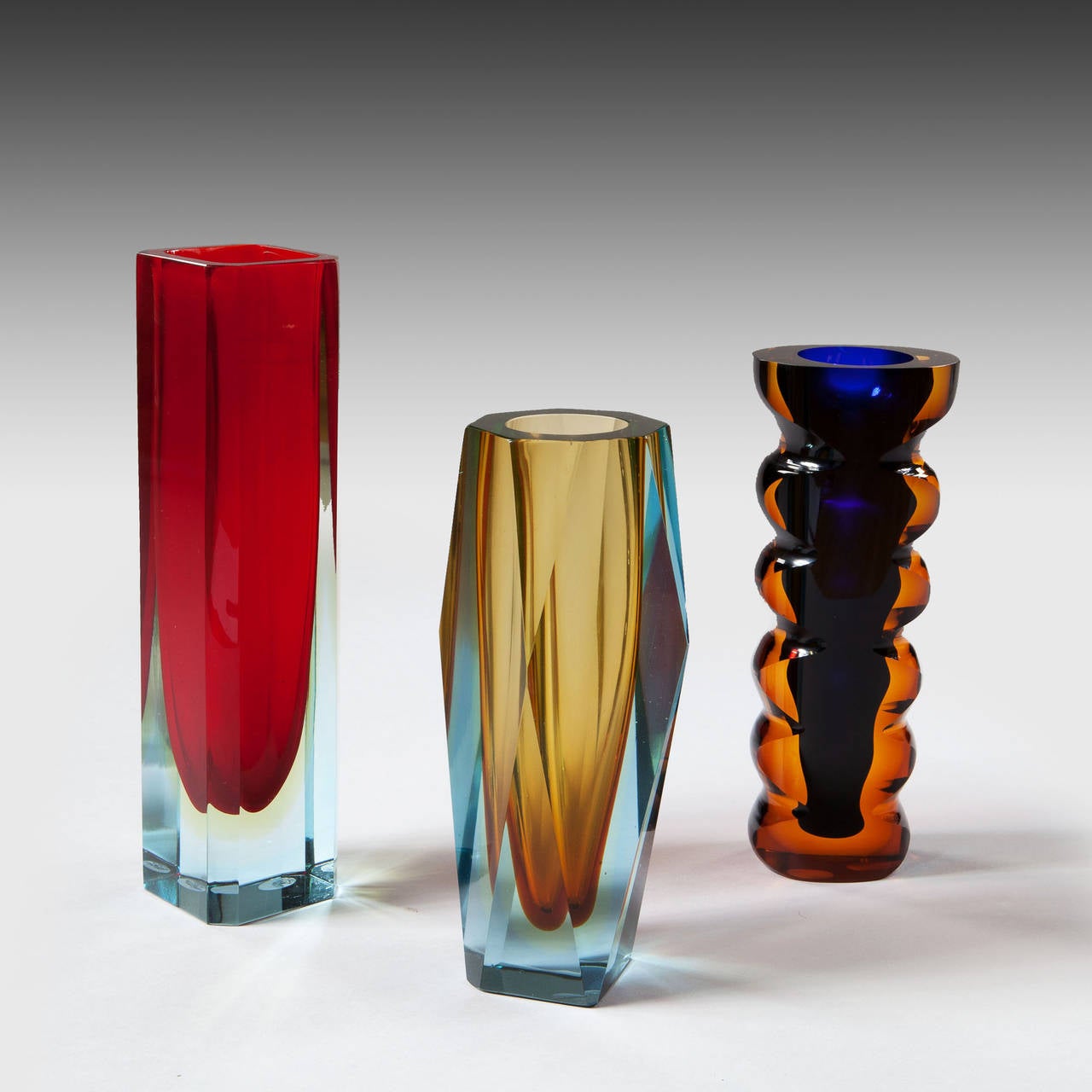 Three mid century Czech’ Murano style Sommerso cut glass vases. Each boldly cut and having mutlitple colour levels.

Unsigned Exbor circa 1970

The red vase height 12 in (30cm)
The amber and aquamarine vase 10 in (25 cm)
Blue and brown vase 9