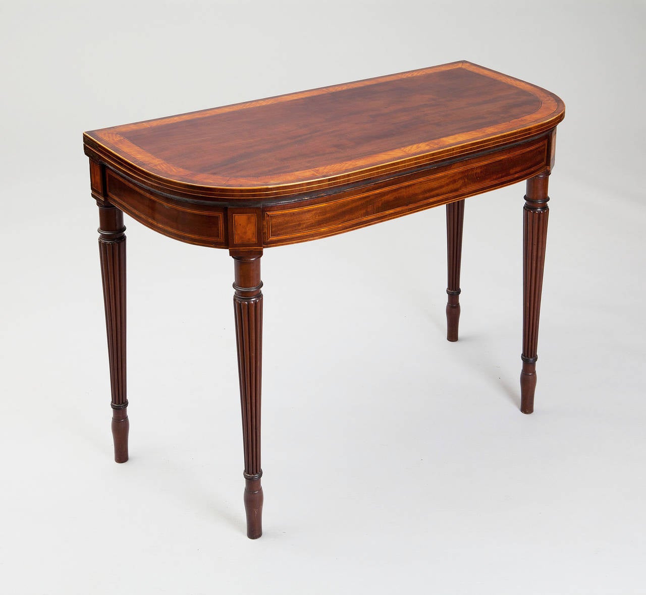 An exceptional pair of late 18th century mahogany card tables attributed to Gillows. The finely figured tops with satinwood banding, the frieze with fielded panels of figured mahogany. Both card tables opening baize interiors and supported on double