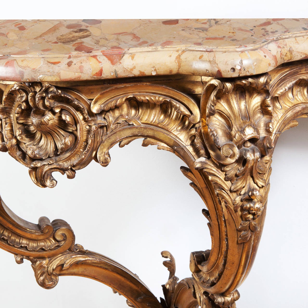 A finely carved mid 19th century Louis XV style gilt wood Rococo console table, voluptuously carve with interning foliate ornament. The table retains its original Brocatelle marble top.