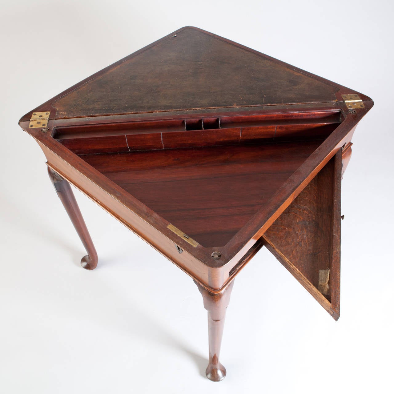 England, circa 1740.

A fine mid-18th century mahogany folding envelope / supper table, the triangular top veneered in fine mahogany inlaid with brass stringing. The lower top, opening to a fitted writing surface with leather top and sunken well.