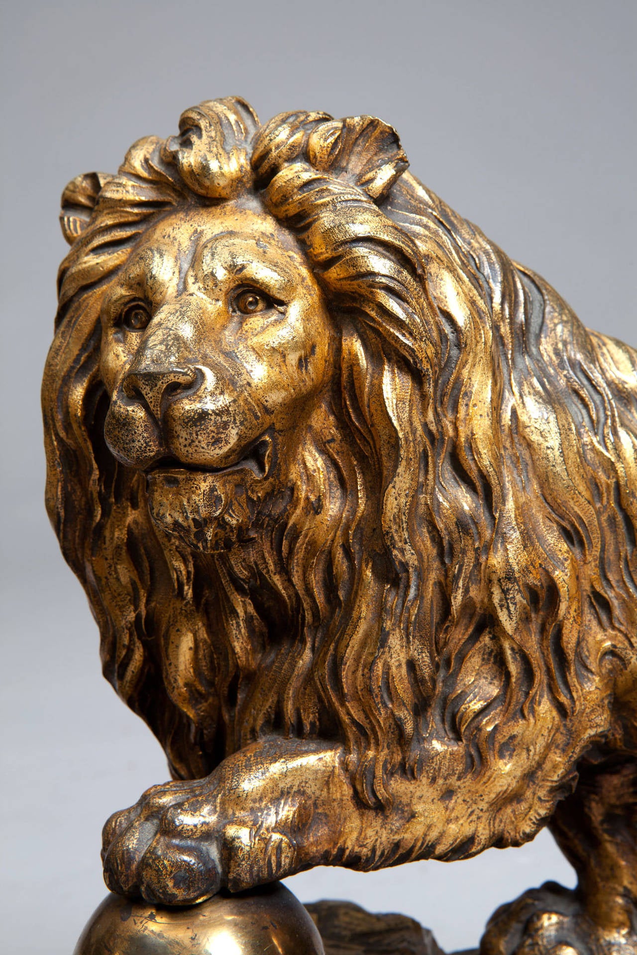 A magnificent pair of large-scale cast bronze and gilt Medici lions, each with one paw raised on a ball. 

Cast in bronze and gilt, their heads turned somewhat to the side and shown with commanding expression, one forepaw resting on a sphere, also