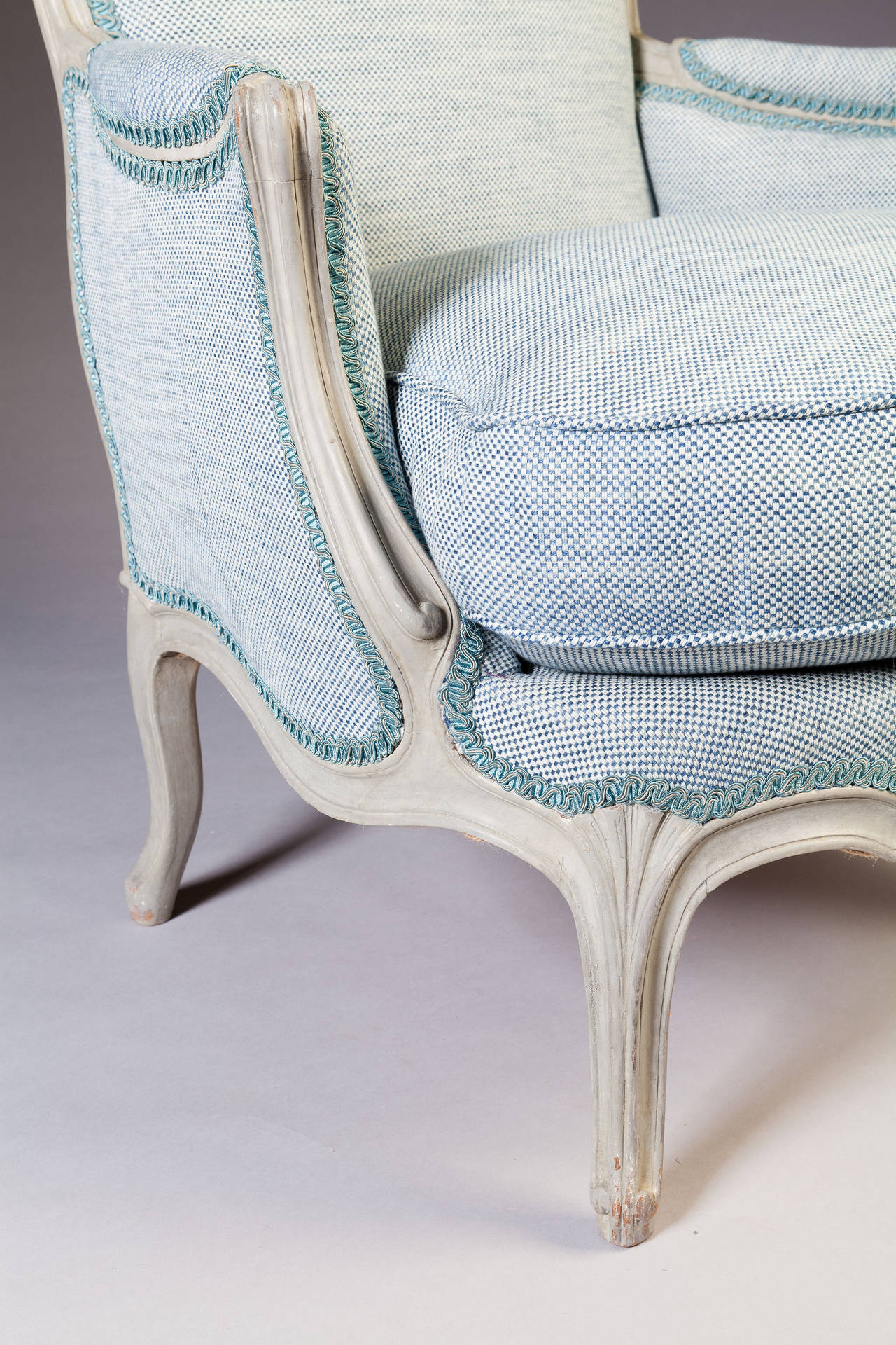 These fabulous bergeres are an unusually large and generous scale. The bergeres with reclined backs of simple outline with channeled detailing, outswept arms of Rococo inspiration raised on cabriole legs with neoclassical fluting.

Newly upholstered