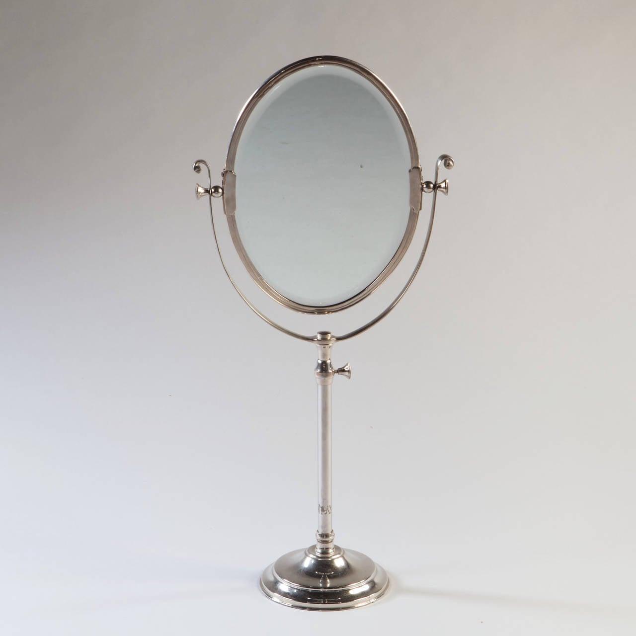 An Edwardian overscale oval silver plate dressing mirror of adjustable height.