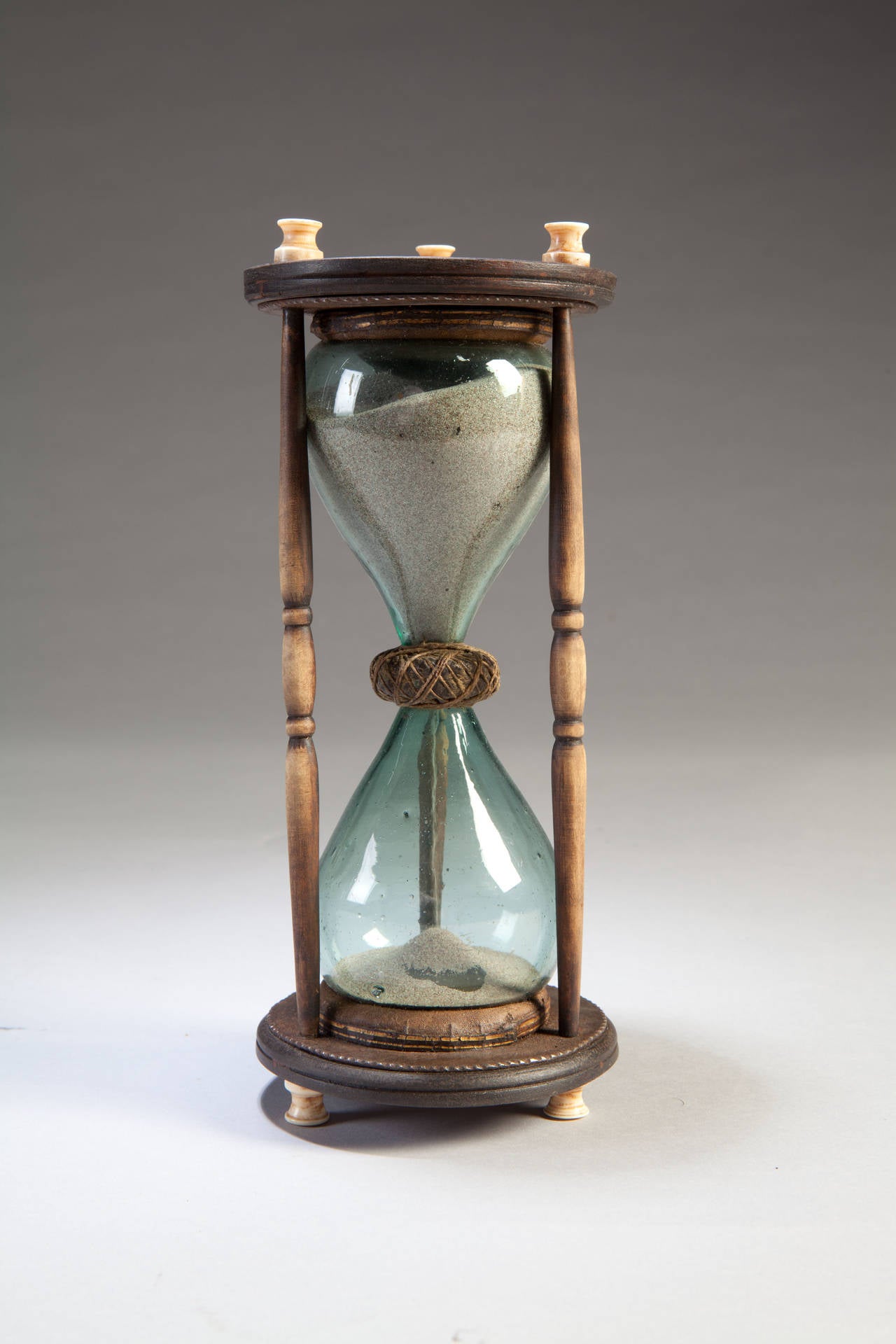 An early 19th century glass sand timer. The glass is supported on leather pads and surmounted and supported by wooden blocks with bone finials. The sides are stained bone double balusters. Probably Flemish, circa 1830.