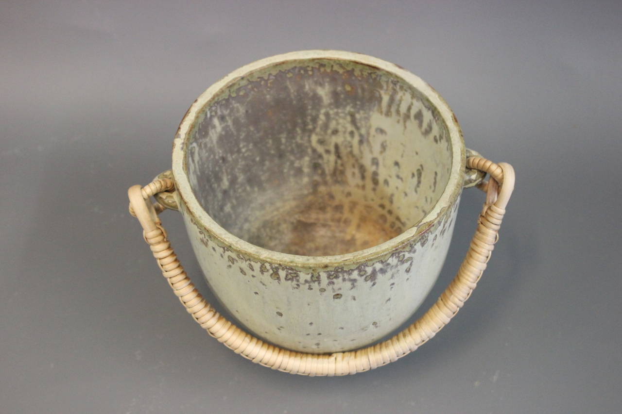 Jar in glazed stoneware of sand-colored shades with paper cord handles. The jar is redesigned by Arne Bang, circa 1940-1960.