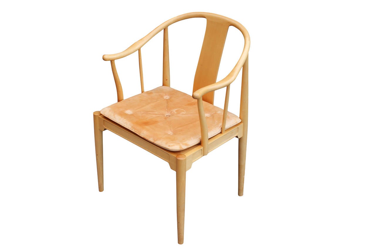 The China chair, model 4283, designed by Hans J. Wegner and manufactured by Fritz Hansen in 1989. The chair is of cherry and with cushion of natural patinated leather. The chair is in great vintage condition.
