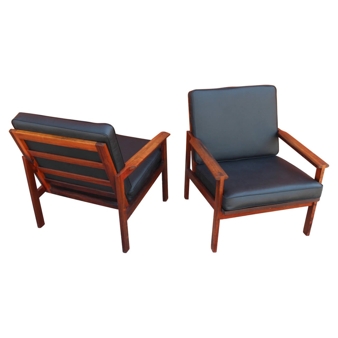 A pair of armchairs by Illum Wikkelsø of the Capella series and manufactured by N. Eilersen. The chairs are from the 1960s and in rosewood with black leather cushions.