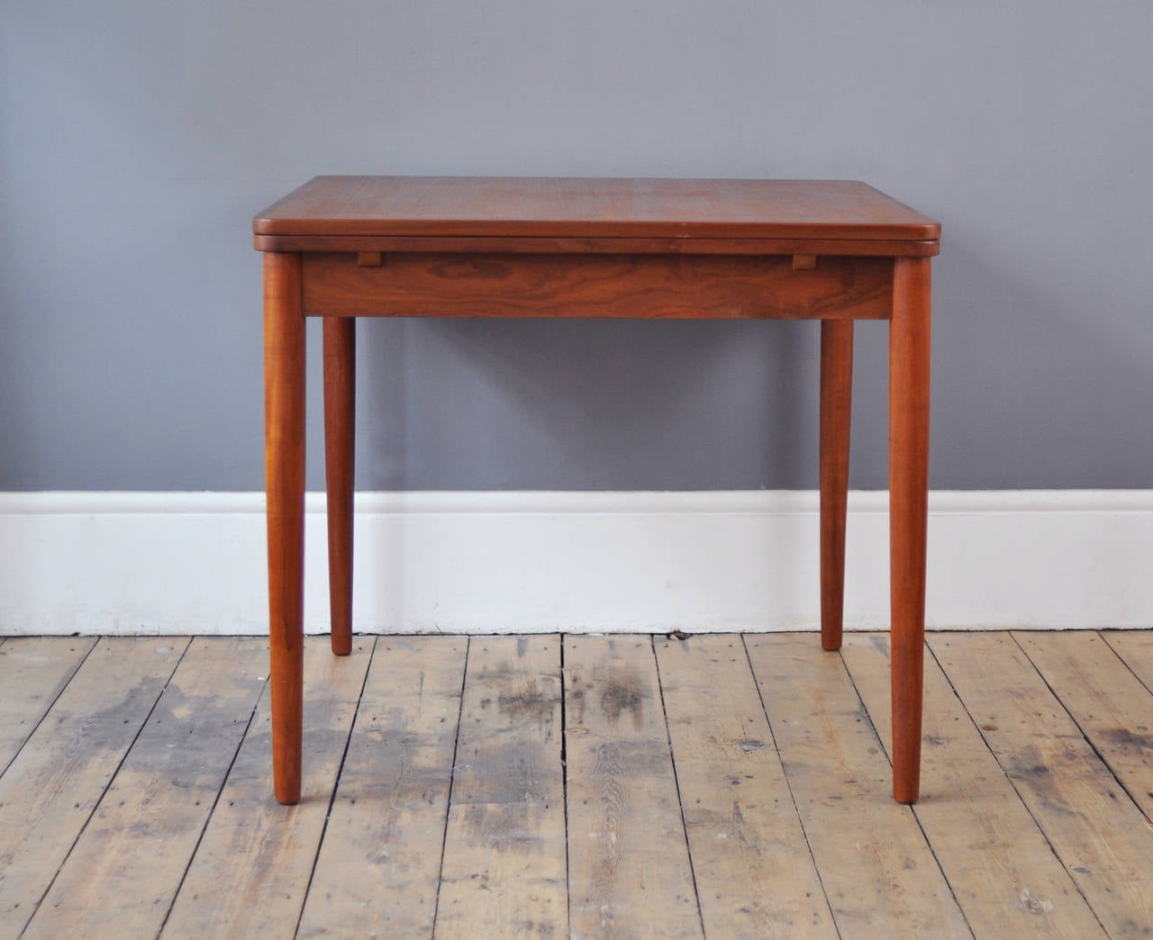 Danish dining table in teak with fine detailing in the tapered legs and bordered edging. Fits neatly into small spaces but expands to seat six people through the two internally stored leaves.

W: 83cm // D: 83cm // H: 73cm

When Extended: W: