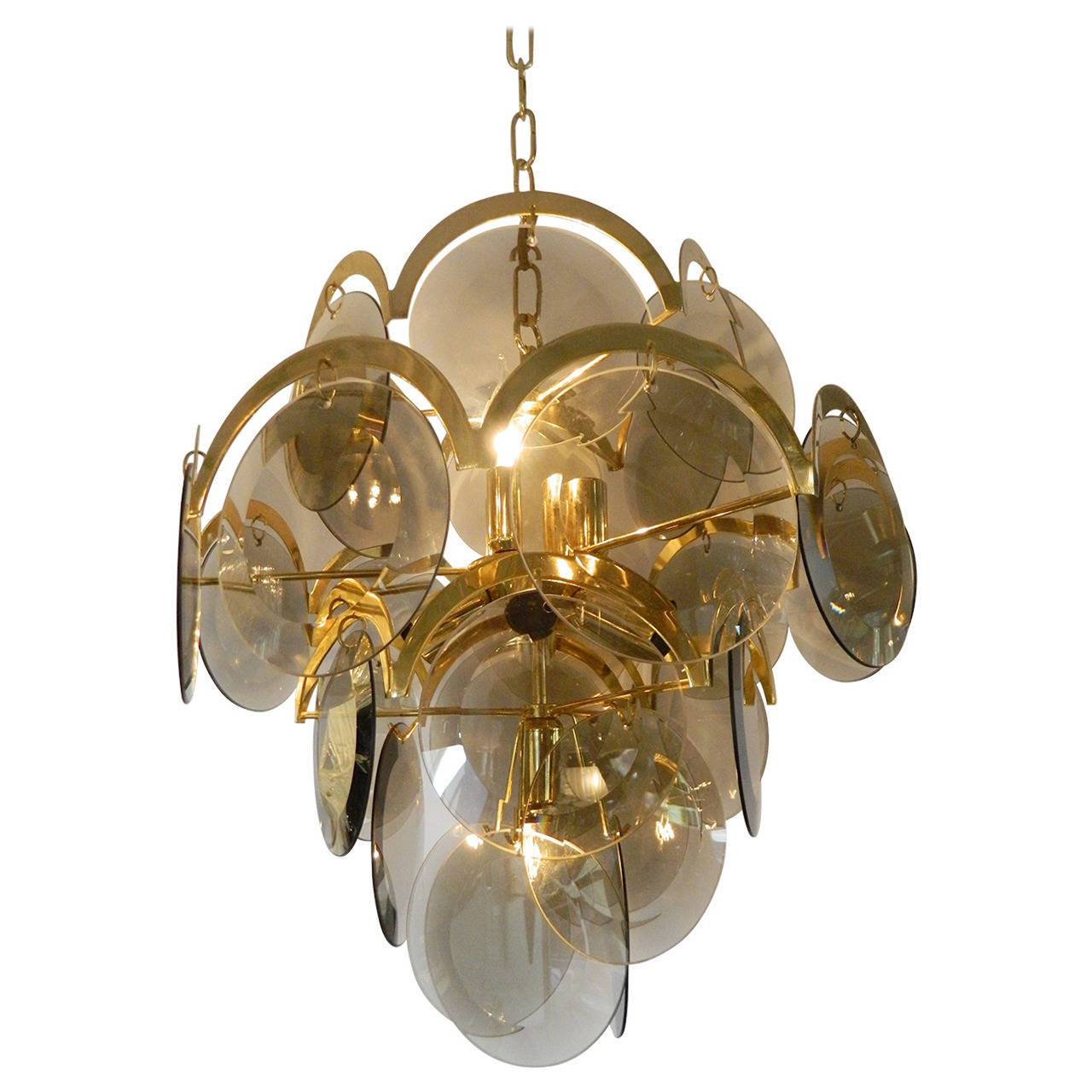 Spectacular 1970s Lightolier smoked beveled glass and brass 27 Disc and ten-light chandelier in the style of Gino Vistosi for Murano by Lightolier. The light reflects nicely off the beveled glass. Measures: 18