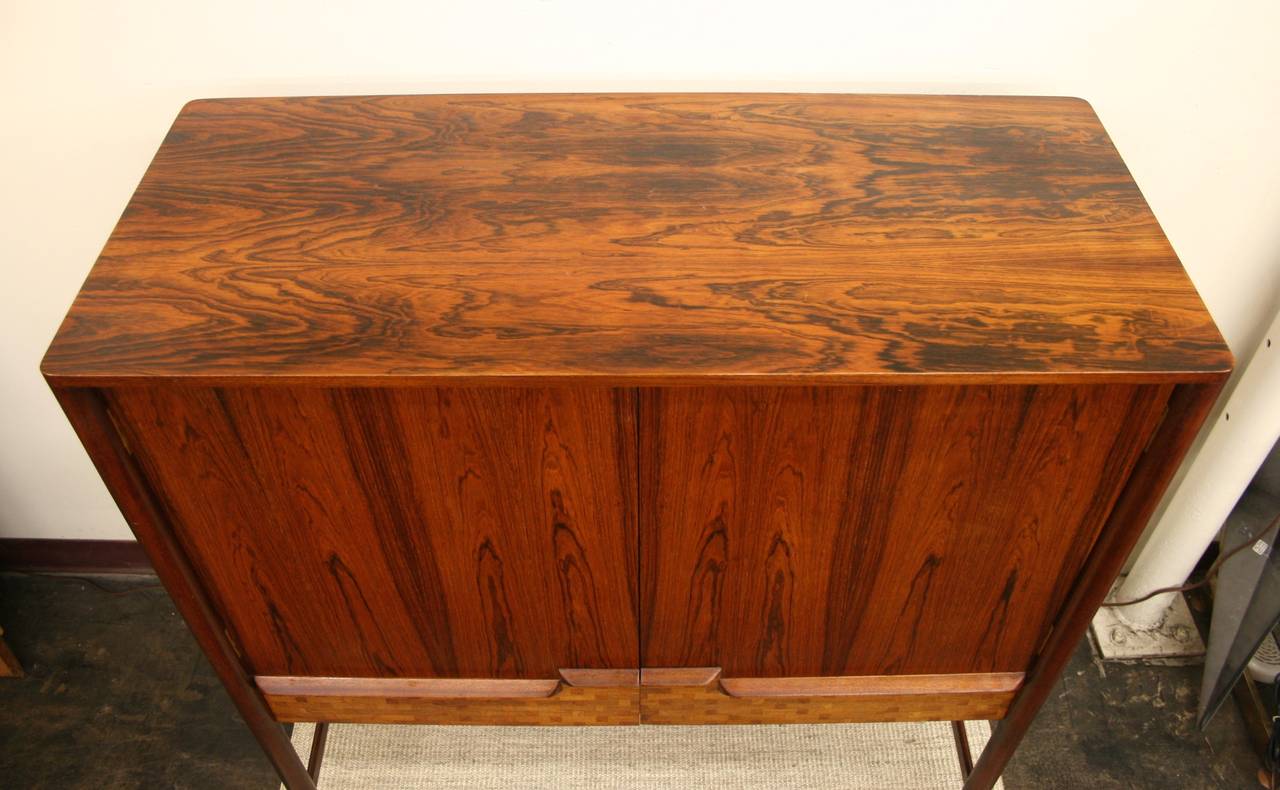 This exceptional piece, featuring a variety of woods, makes a wonderful credenza, dry bar or buffet. Main compartment doors swing open; inside, the spacious shelves hold plenty of glassware and spirits. Underneath the main compartment, two drawers,