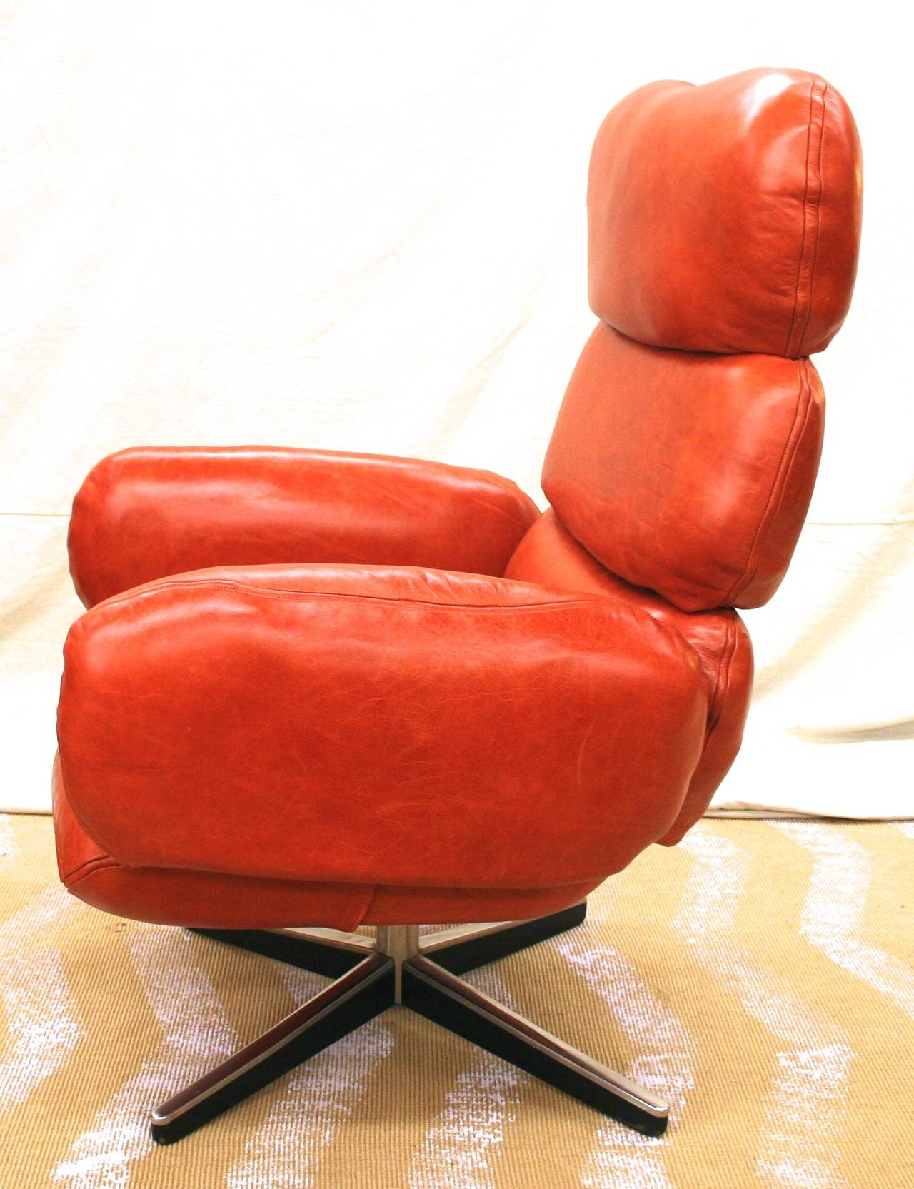 Comfortable, cushioned executive style desk chair on swivel base, designed in the style of Otto Zapf for Knoll. Swivels and reclines smoothly. Newly upholstered with leather, whose beautiful natural grain shows through the red-orange finish. Otto