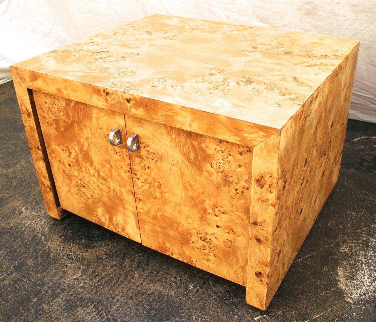 Lushly figured caramel colored burled wood distinguishes this low cabinet in the style of Milo Baughman. Each face of the chest features book matched grain patterns for striking effect. Featuring extra depth for exceptional storage, this striking