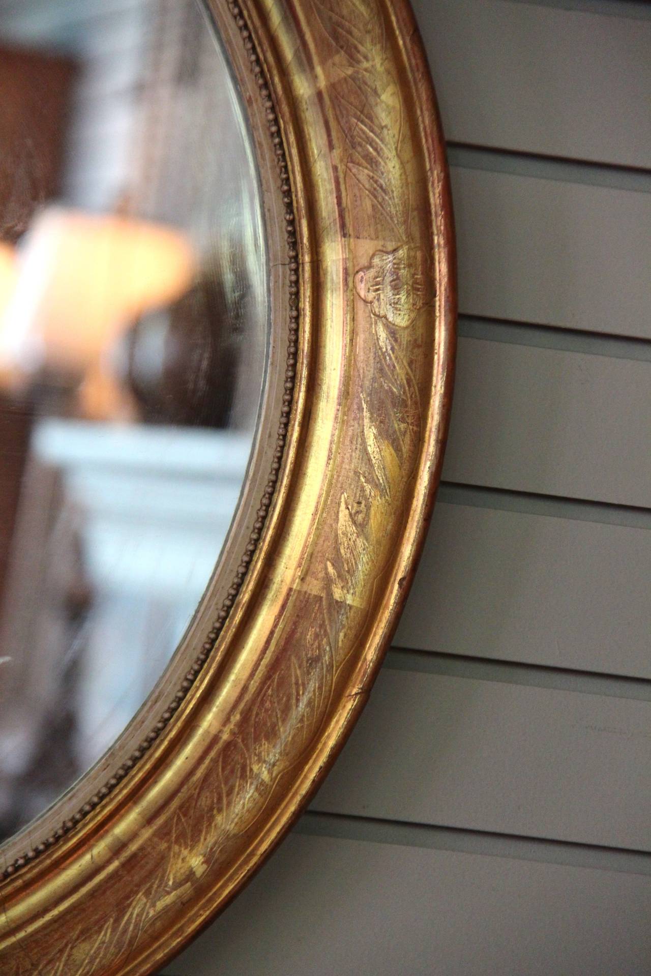 Pair of oval mirrors with engraved giltwood.  Original glass.