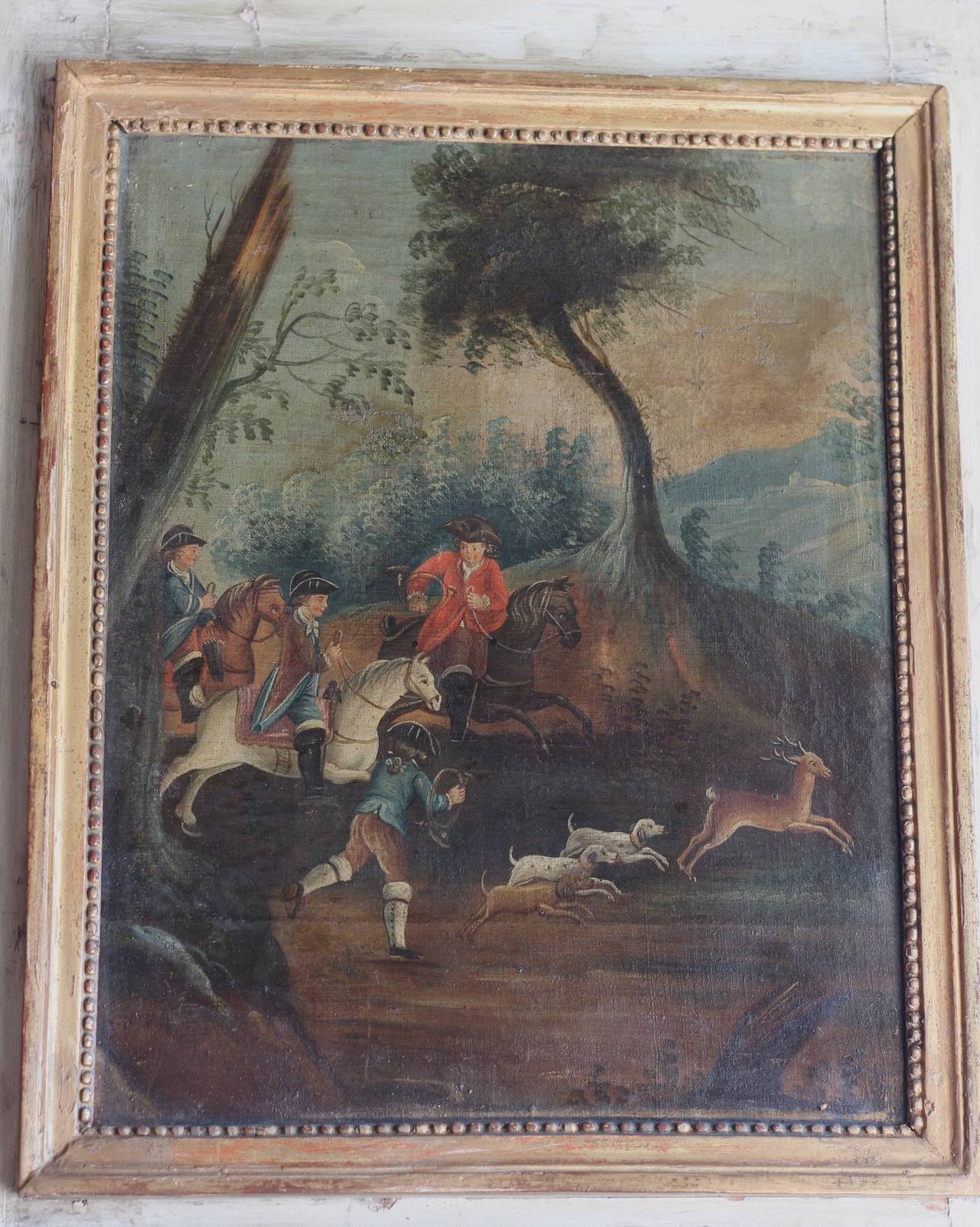 Beautiful 18th Century Trumeau Mirror with gilt wood molding.  Oil on canvas.  Woodland landscape painting of riders in red jackets and animals.