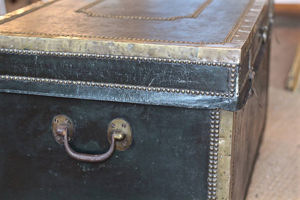 Handsome Chinese export camphorwood trunk covered in dark green black leather with brass studs, brass edging and brass carrying handles.  Rare large scale.