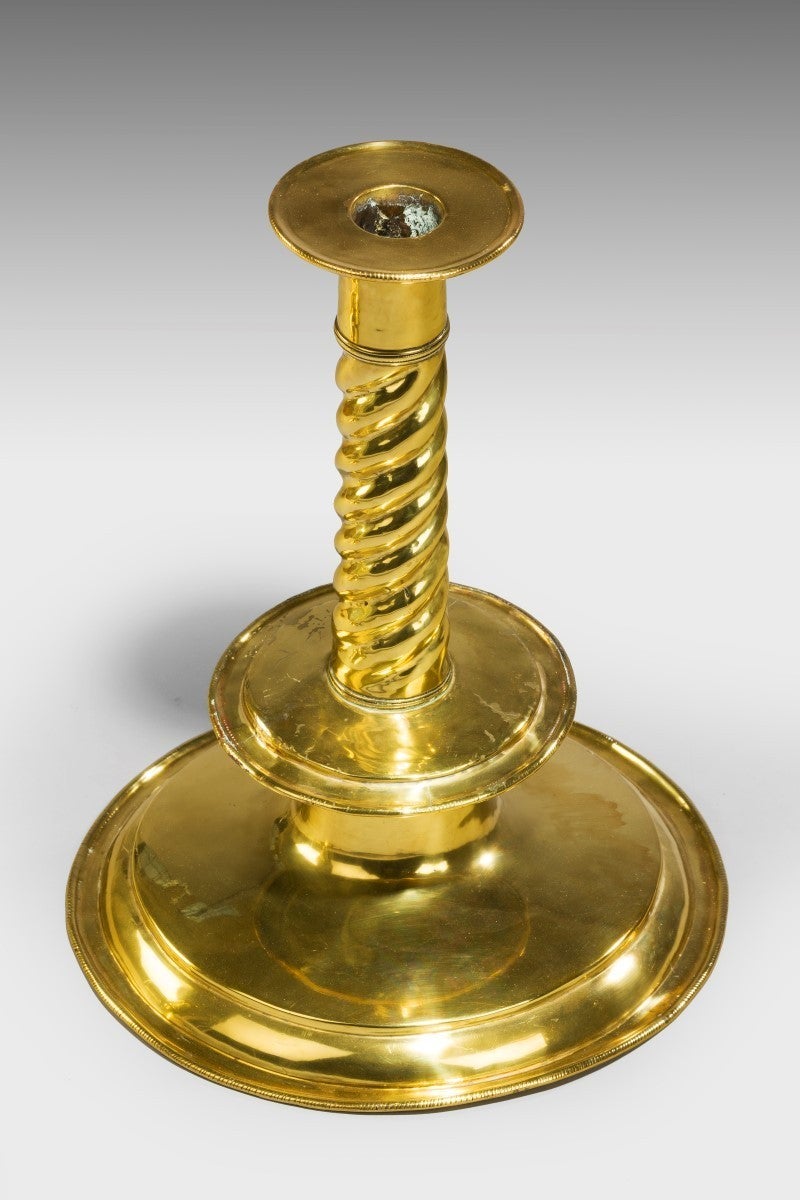Provenance: Previously at Newton Surmaville House, Somerset.

A rare and important pair of late 17th Century brass trumpet-based candlesticks, with a ribbed or ‘corded’ decoration on the upper stem which terminates at the drip-pan. The removable