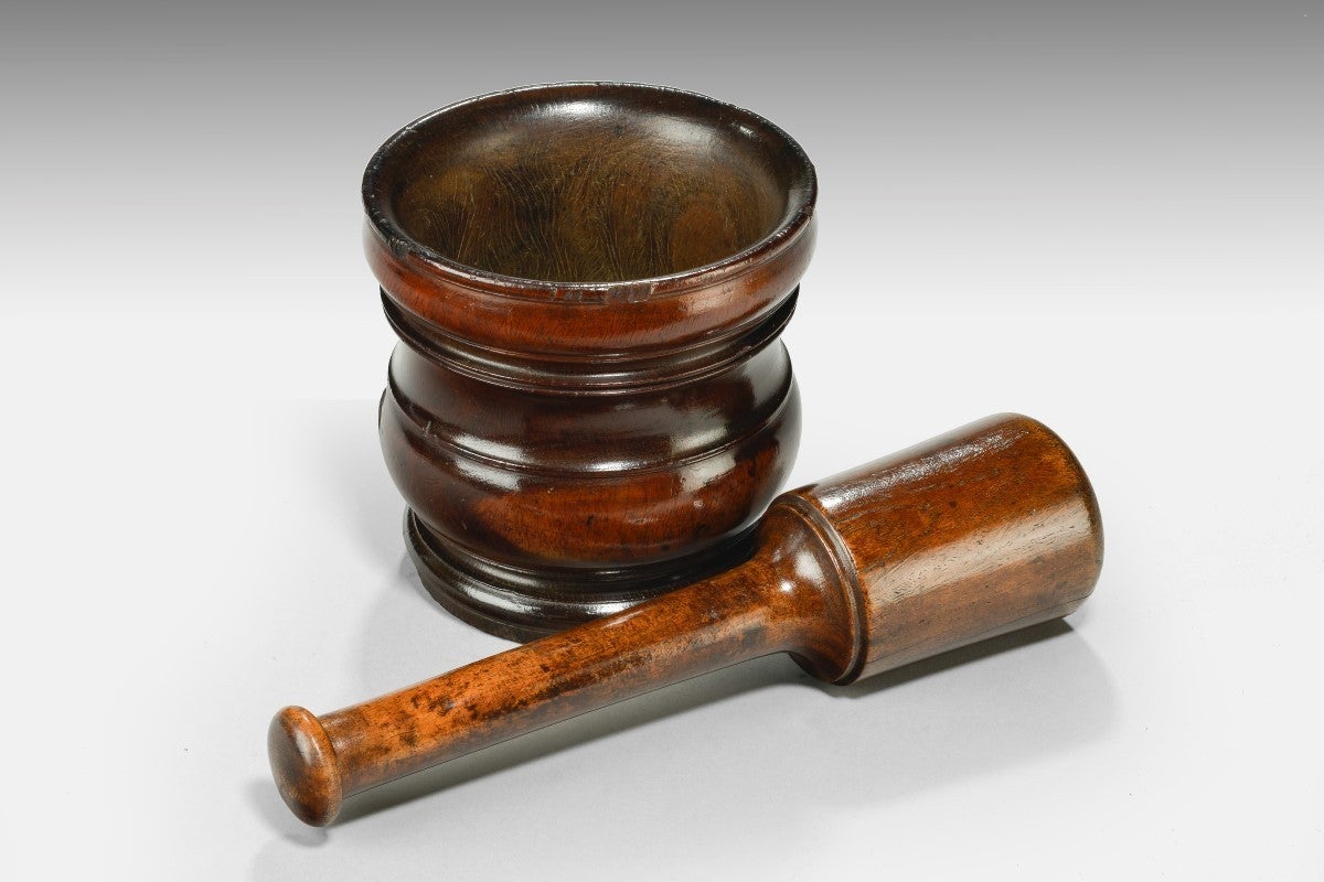 Turned with a pair of rings just beneath the rim, and with bulbous turning to the foot, with stamped mark ’28′ to underside. Together with an associated late 17th/early 18th century lignum vitae pestle.