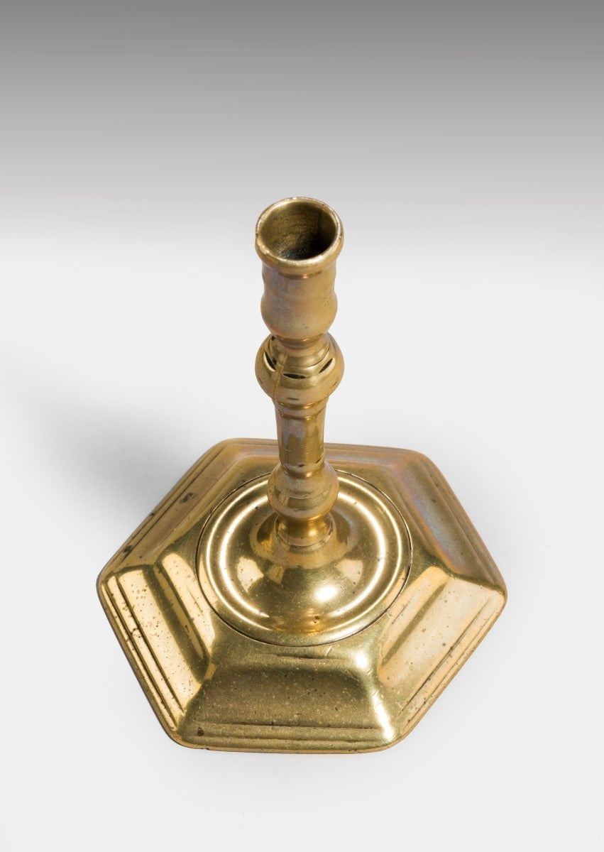 With a hexagonal base and a deep socket to ensure that the small taper was held firmly. 

Tapersticks are miniature candlesticks, principally intended for melting sealing wax and mainly used on tables and desks, but also used for lighting of