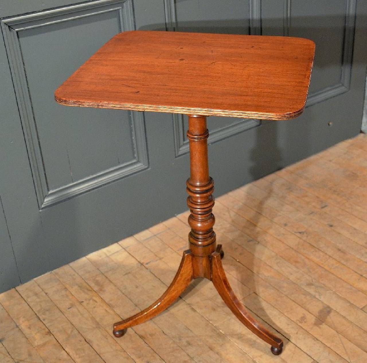 This versatile sized Regency mahogany tilt top wine table features a turned central base with three splay legs on ball feet. The table measures 20 in – 51 cm wide, 18 in – 45.7 cm deep and 28 in – 71 cm high when in opened table position. When the