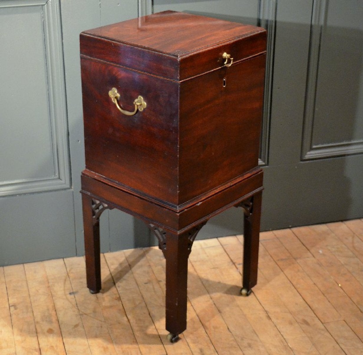 A very good quality George III mahogany cellarette on a squared leg stand features a nice bit of detail with open fret work supports, along with brass hardware and castors. The cellarette measures 12 inches, 30.5 cm square width and depth and stands